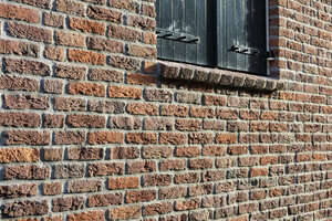 Historic brick wall and black wooden shutters in Noord-Brabant, 
