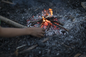 Vuur in de nacht met hand naar de vlam