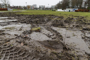 Modderig, spoorvormig grasveld in park