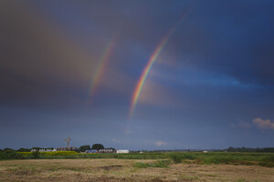 Regenboog over landelijk landschap