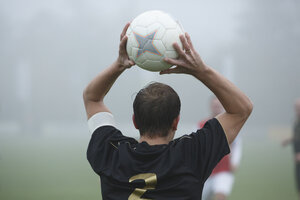 Voetballer bereidt ingooi voor in mist