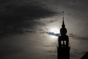 Silhouette of a church tower against a dramatic sky in Noord-Bra