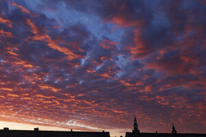 Dramatische zonsondergang boven daklijnen