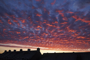 Kleurrijke zonsondergang boven daken
