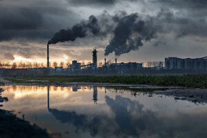 Industriecomplex bij schemering, rook en reflectie