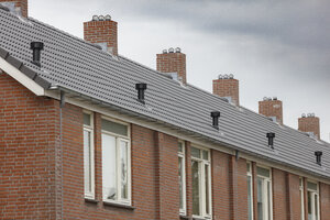 Rij bakstenen huizen met grijze daken