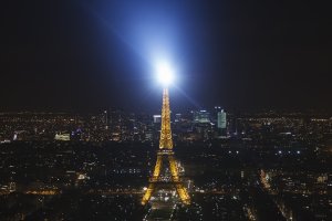Eiffeltoren schittert 's nachts boven Parijs