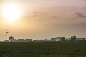 Windturbine tegen zonsondergang op het platteland