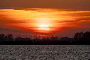 Levendige rode zonsondergang boven brede rivier