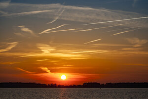 Levendige rode zonsondergang boven brede rivier