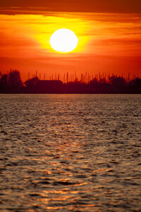 Levendige rode zonsondergang boven brede rivier