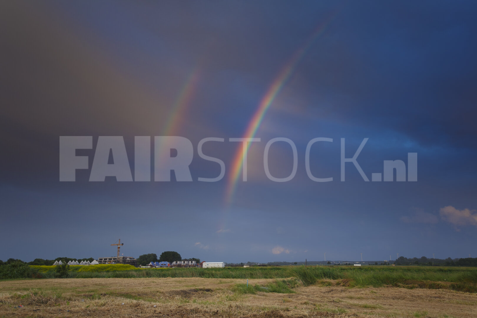 Regenboog over landelijk landschap