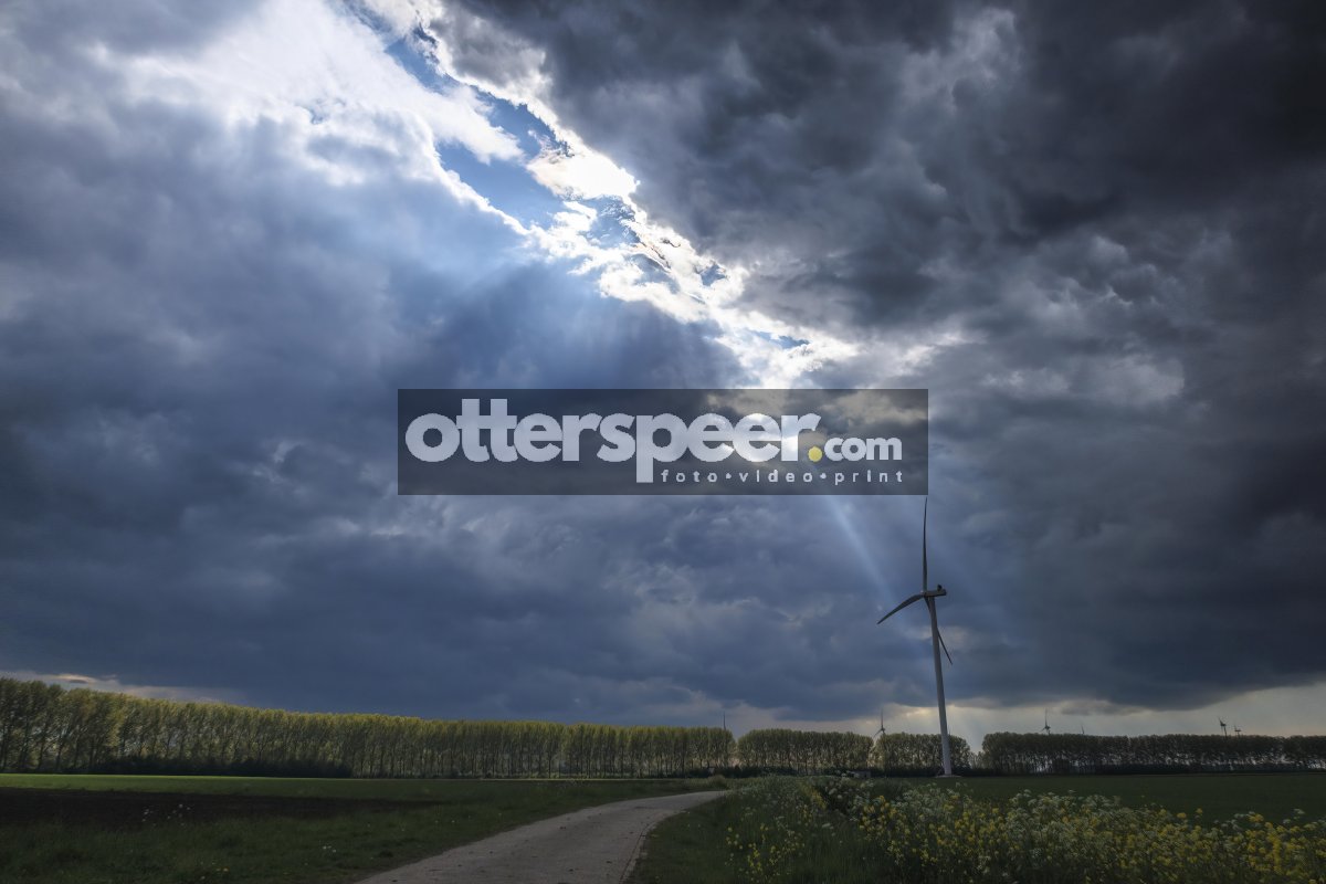 Dramatic cloud formation highlights wind turbine in rural landsc