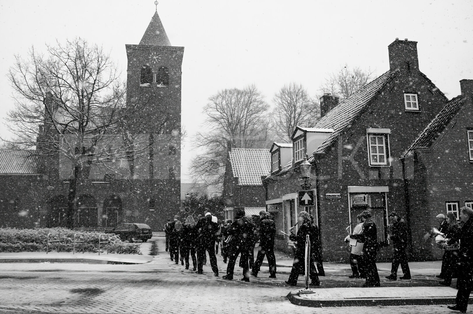Harmonieorkest in sneeuwstorm door dorp