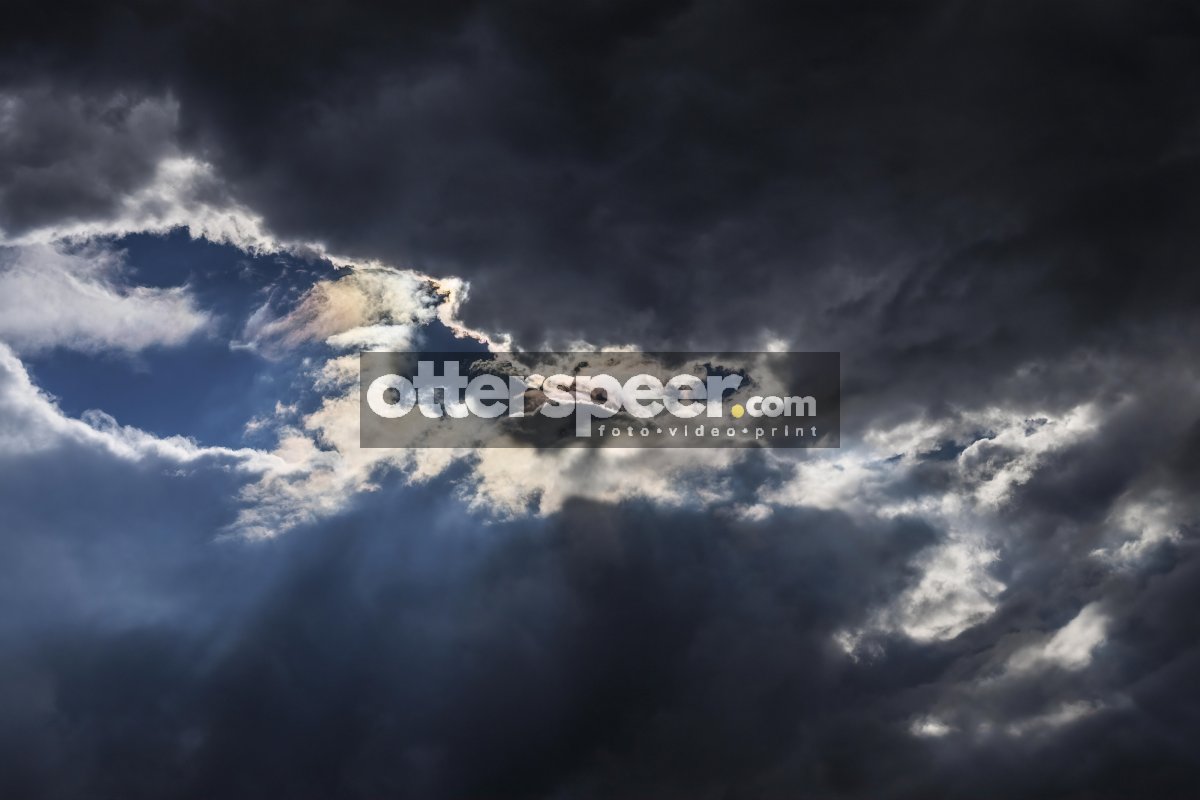 Dramatic sky with dark clouds and a glimpse of sunlight breaking