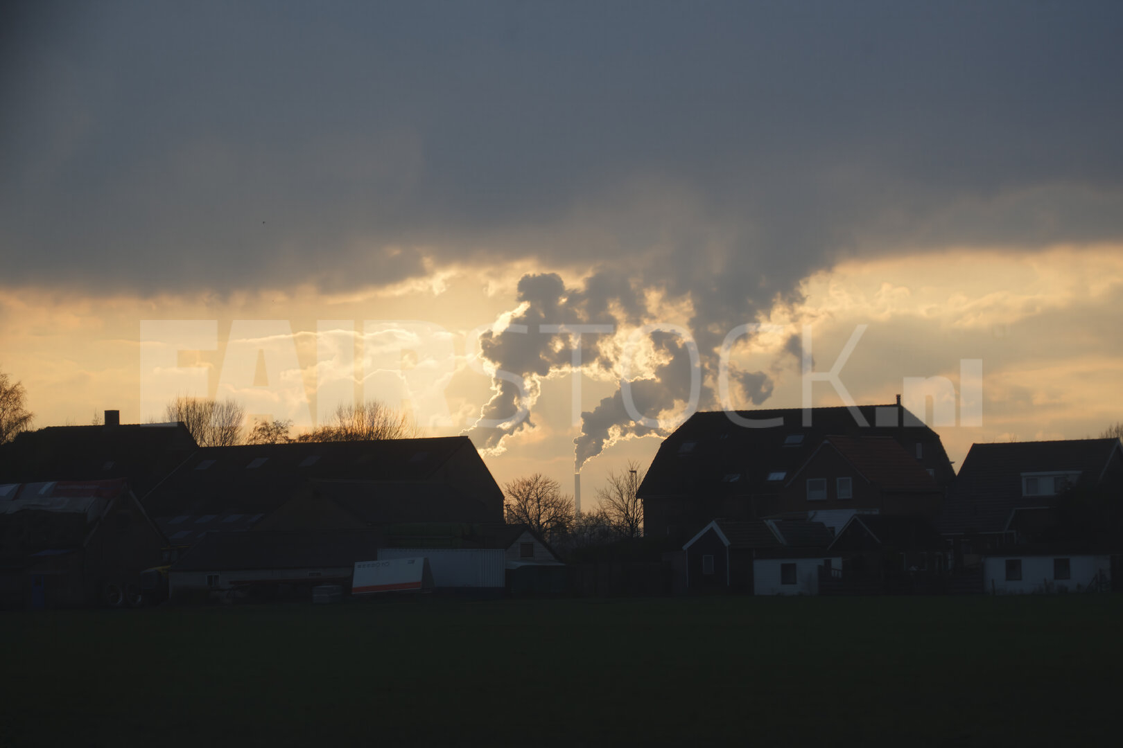 Nederlands landschap met lage wolken en warme zonsondergang