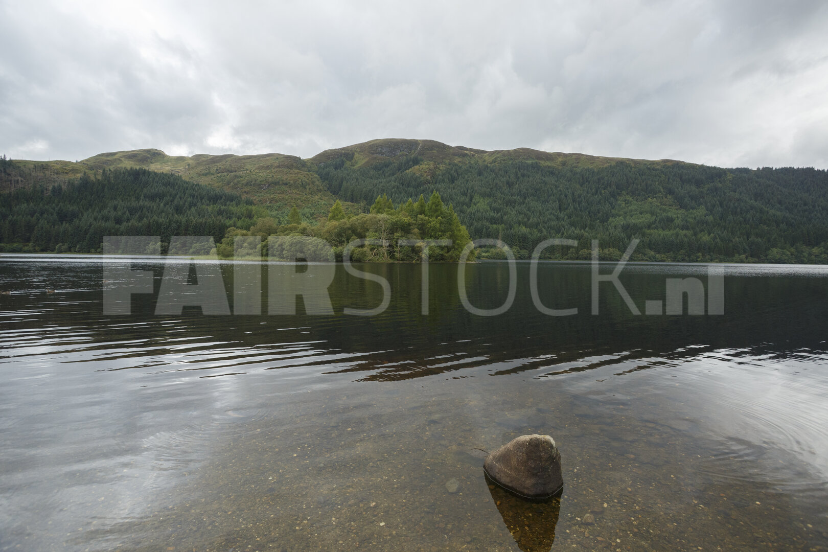 Bergmeer met steen aan de oever