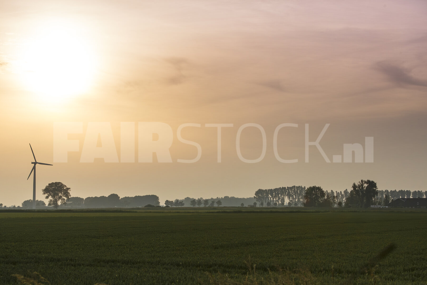 Windturbine tegen zonsondergang op het platteland