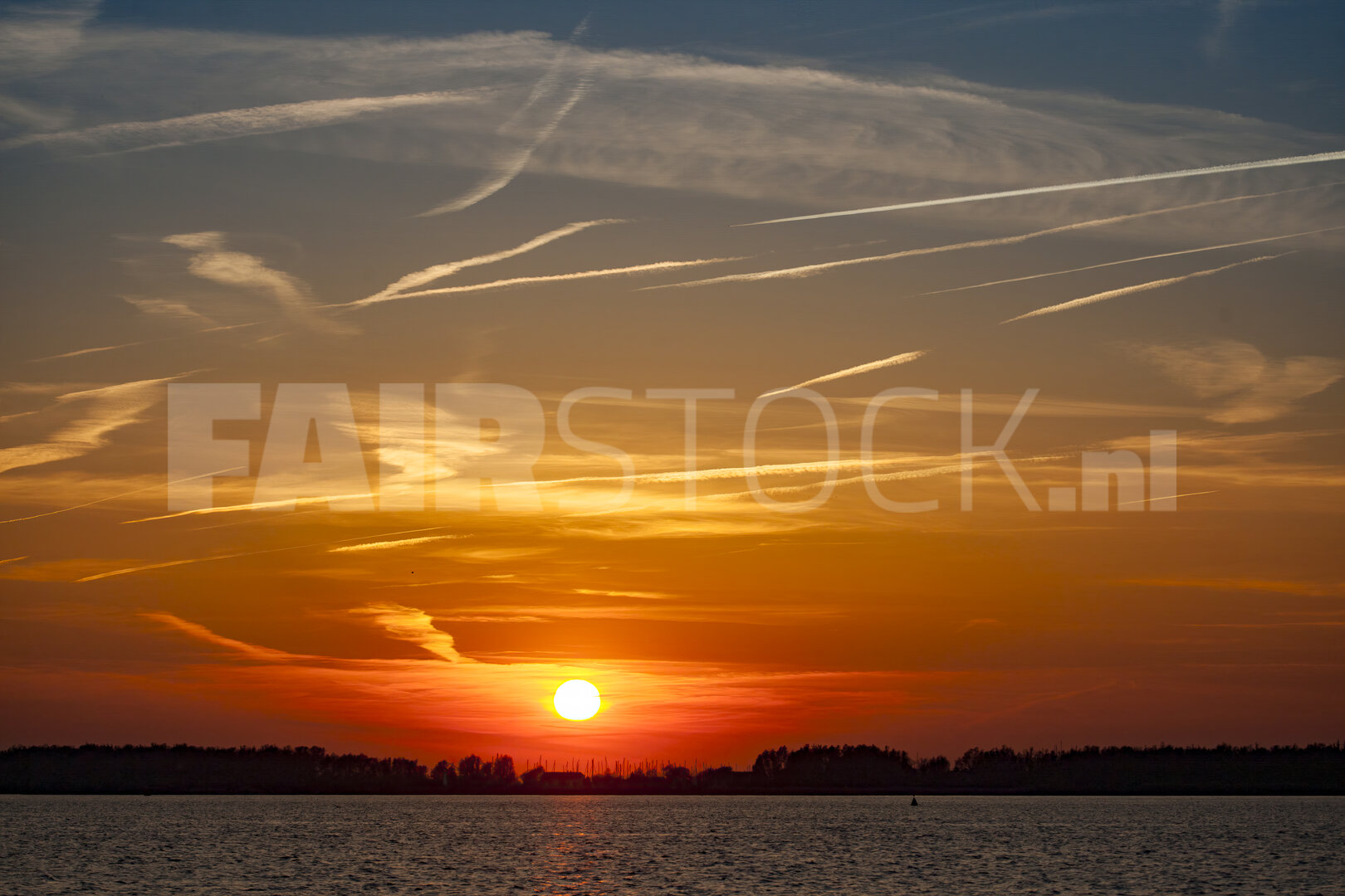 Levendige rode zonsondergang boven brede rivier