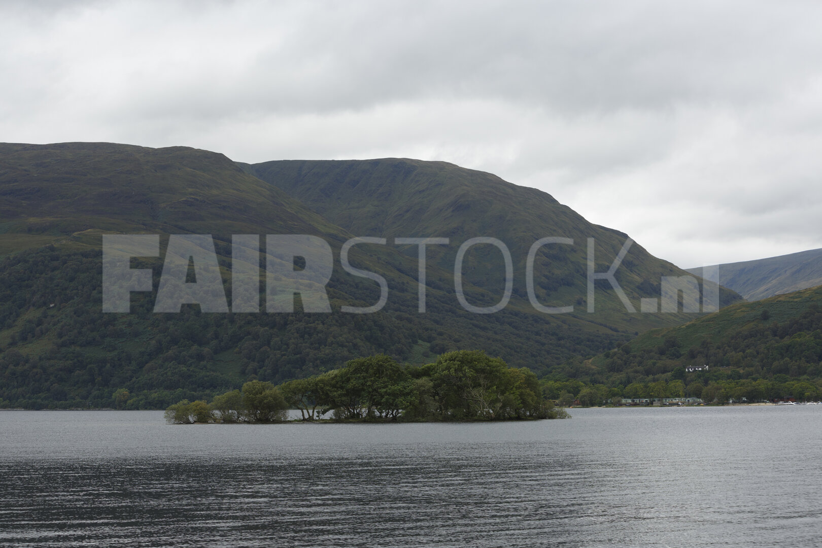 Rustig meer tussen bergen en wolken