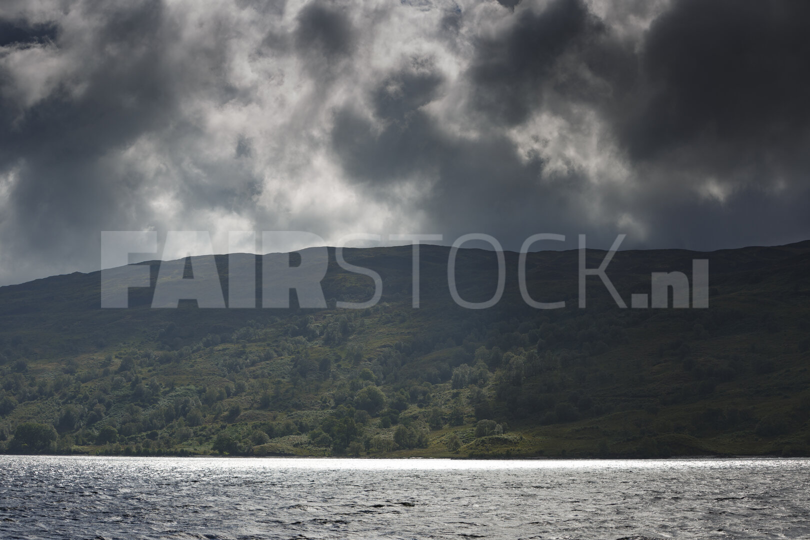 Dramatische wolken boven rustig bergmeer